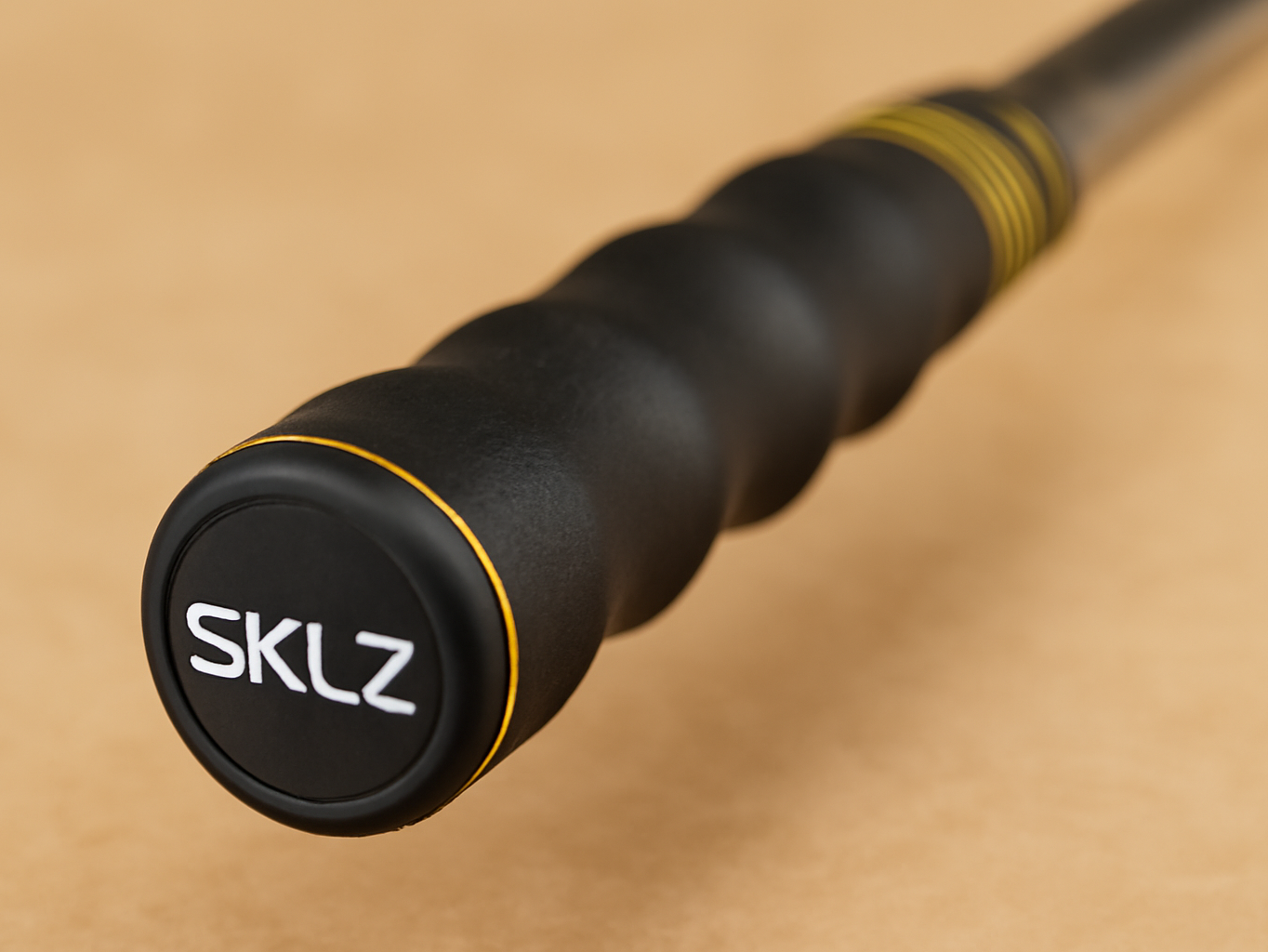Macro close-up of SKLZ Golf Swing Trainer grip showing textured surface and finger grooves in sharp detail
